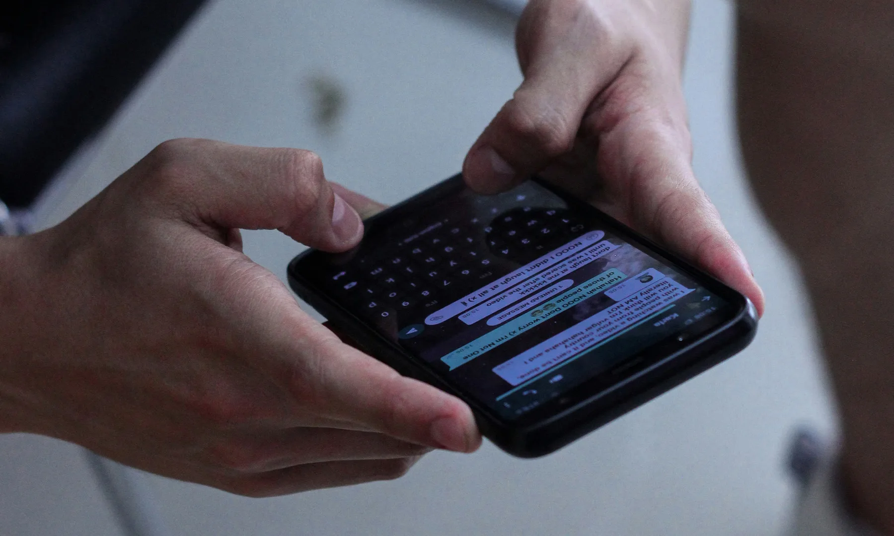 Hands typing a message on a phone