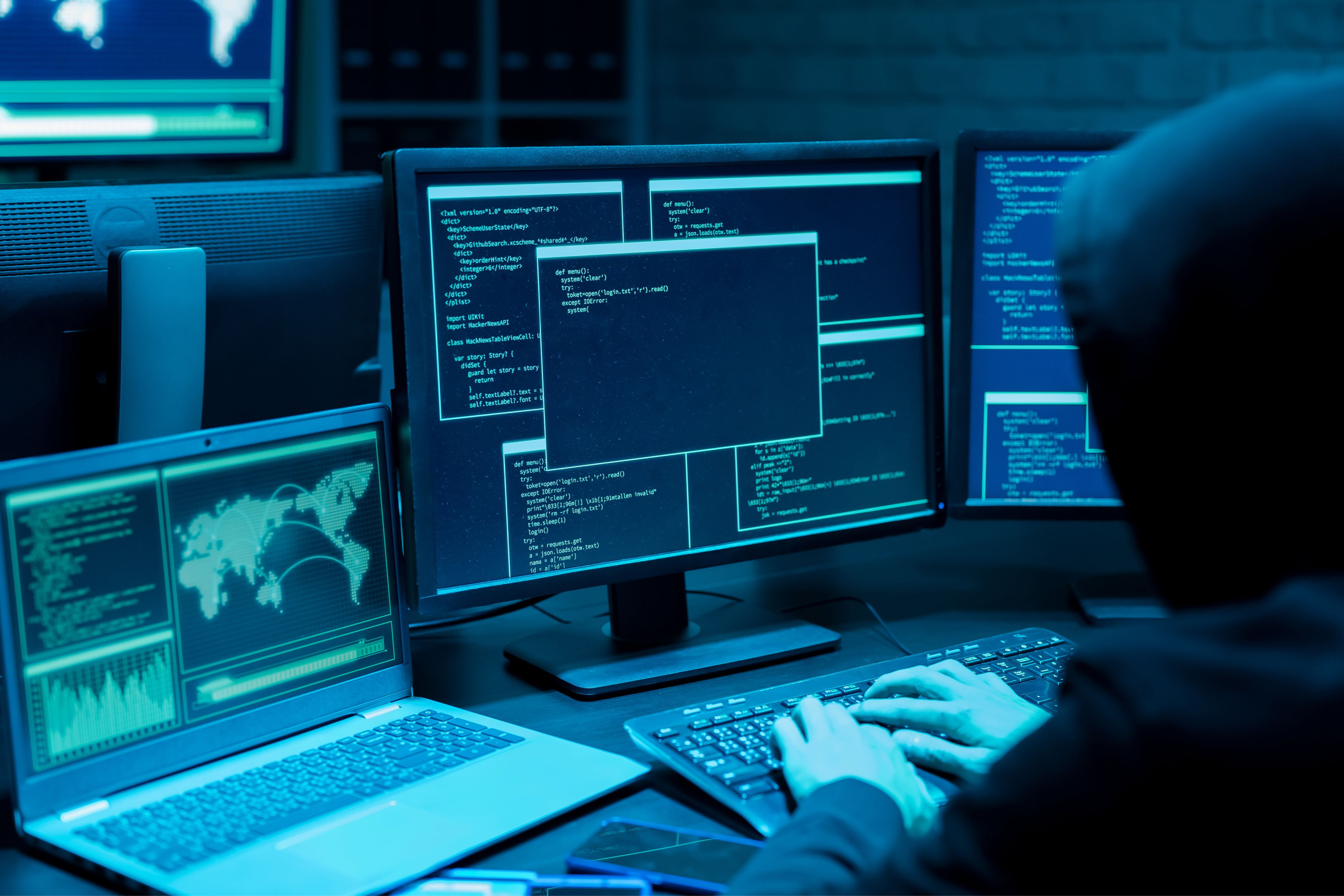 Attacker working at several screens of code