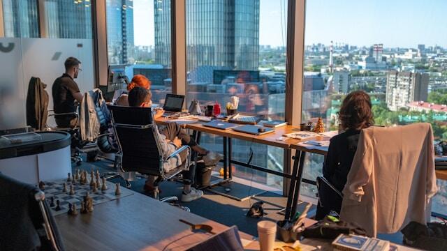 Team working on laptops in an office with a city view