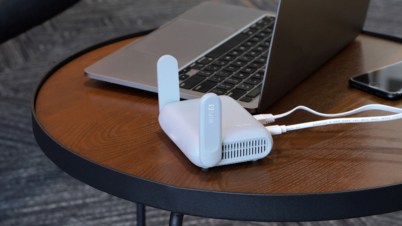NomaPort Roam VPN hotspot next to a laptop on a café table